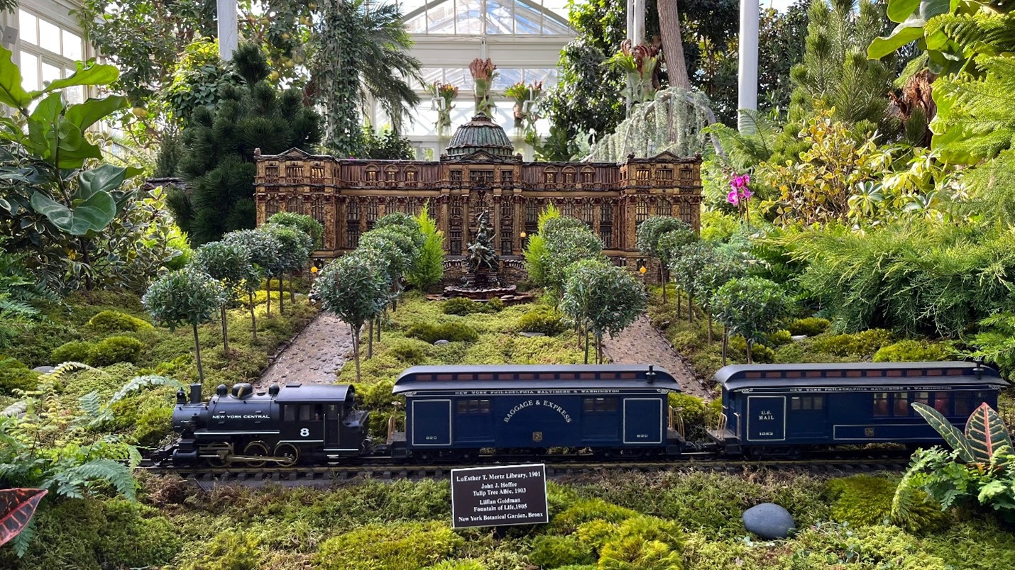 A blue train in front of a mini-building seen during a one-day sightseeing tour