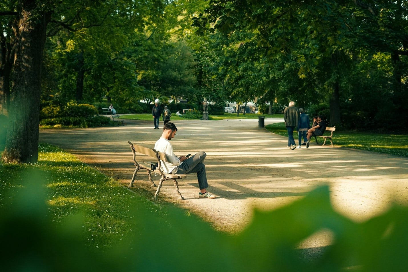 People sitting on benches in a park during a city trip to New York