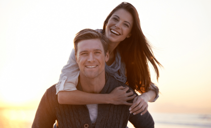 A young carefree couple piggybacking while traveling.