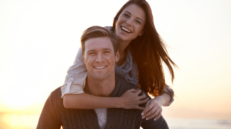 A young carefree couple piggybacking while traveling.