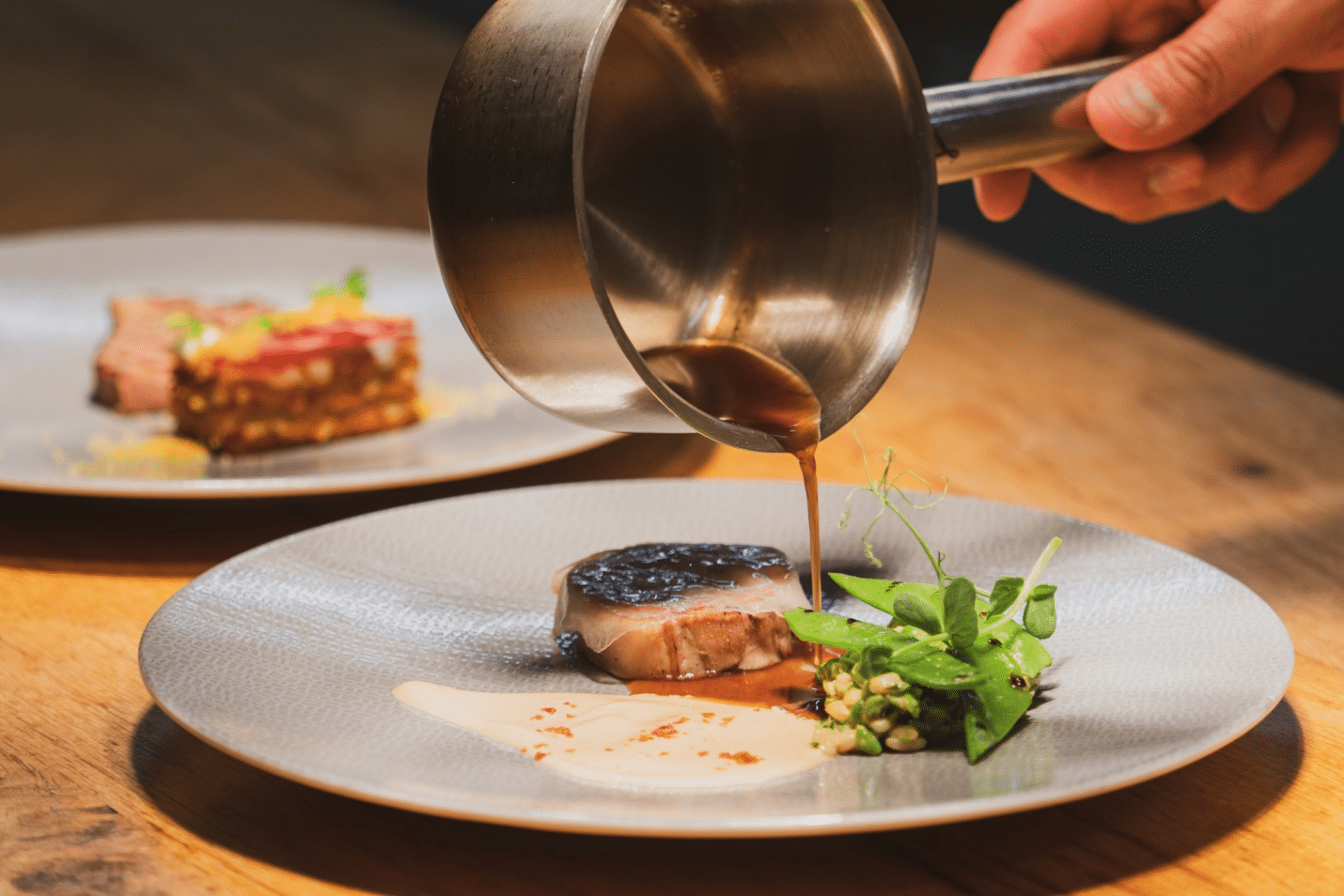 Sauce being poured on a dish at a restaurant
