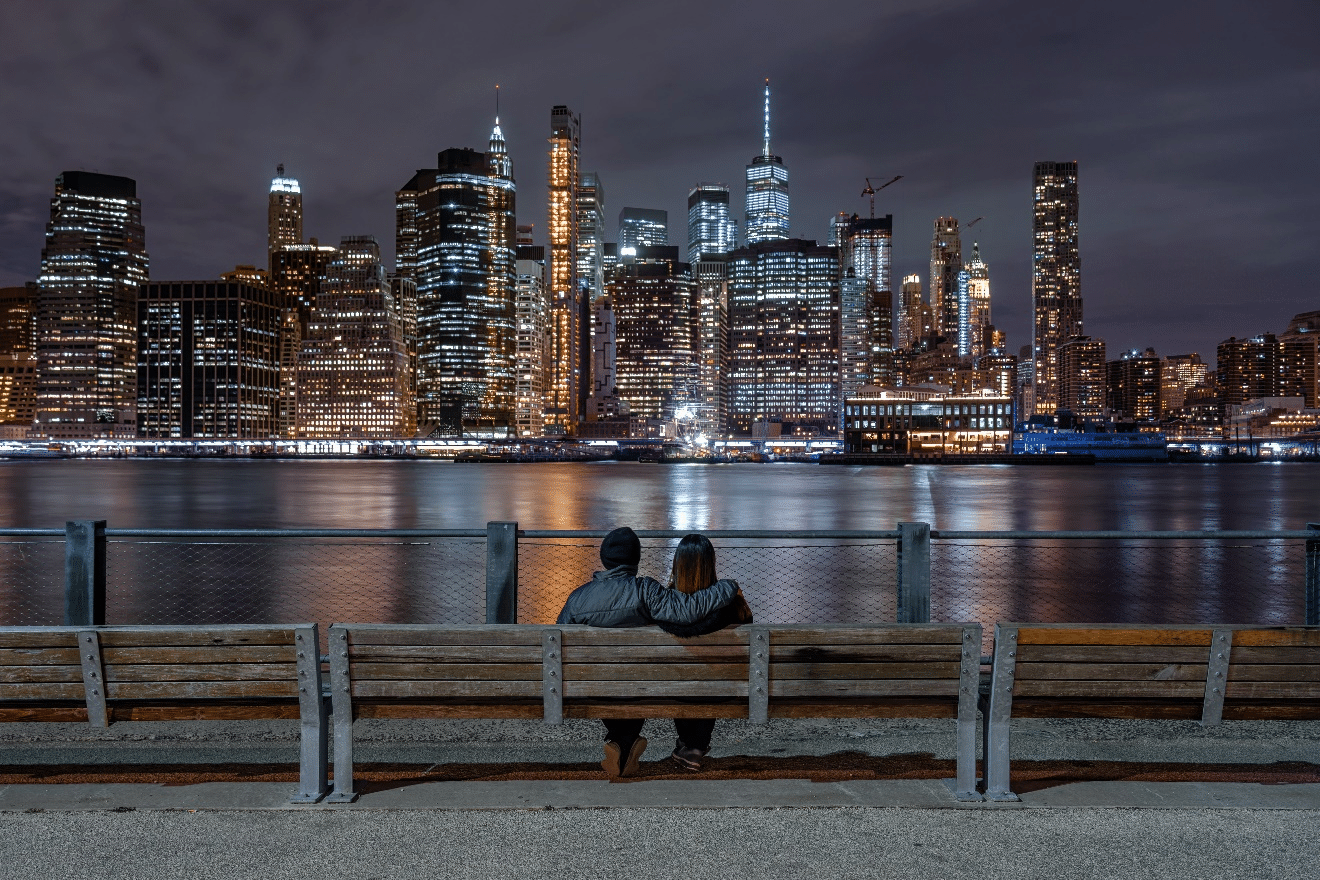 Couple sitting on a bench overlooking the New York skyline