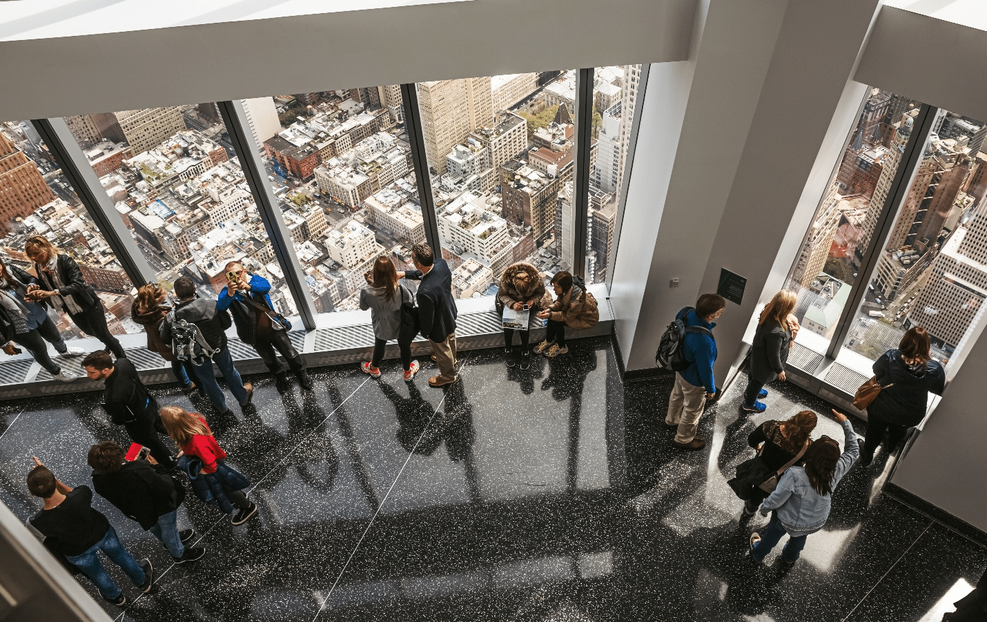 People standing in a room with large windows for views during a one-day sightseeing tour