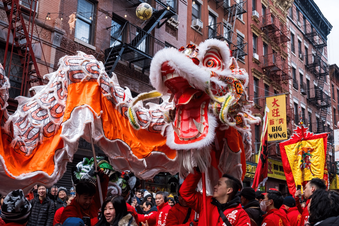 People holding up an orange dragon figure during a one-day sightseeing tour