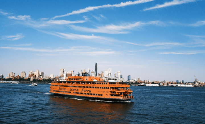 The Staten Island Ferry departing from Manhattan with the Statue of Liberty in the distance.