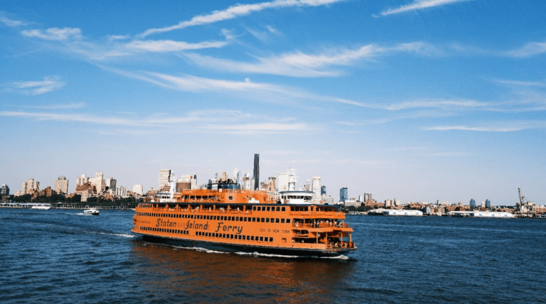 The Staten Island Ferry departing from Manhattan with the Statue of Liberty in the distance.