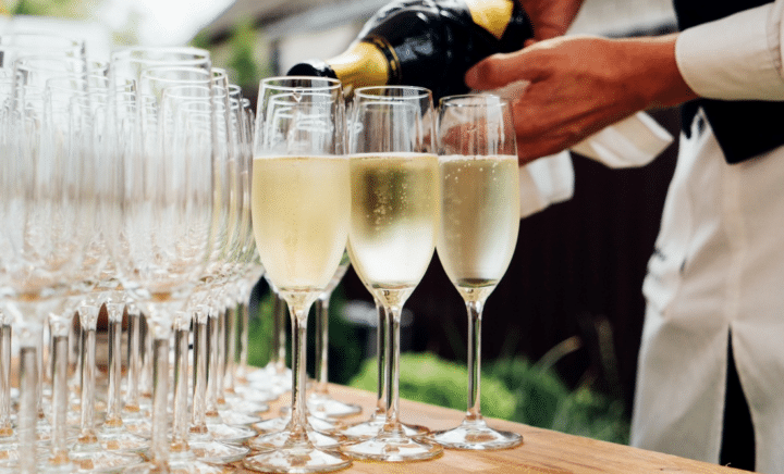 A waiter pouring wine in glasses