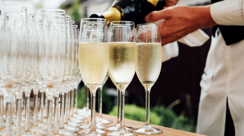 A waiter pouring wine in glasses