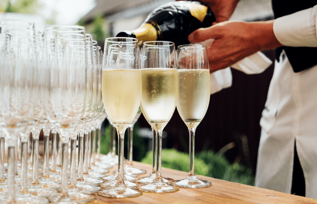 A waiter pouring wine in glasses