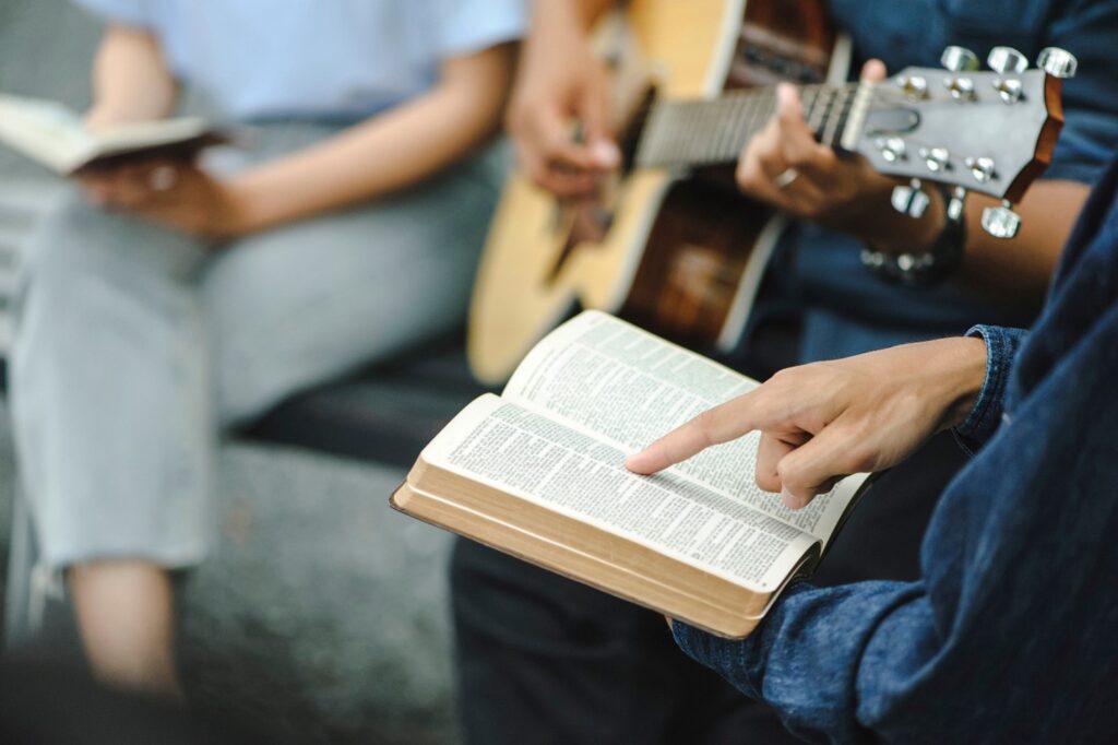 A diverse congregation holding hands in prayer inside a church.