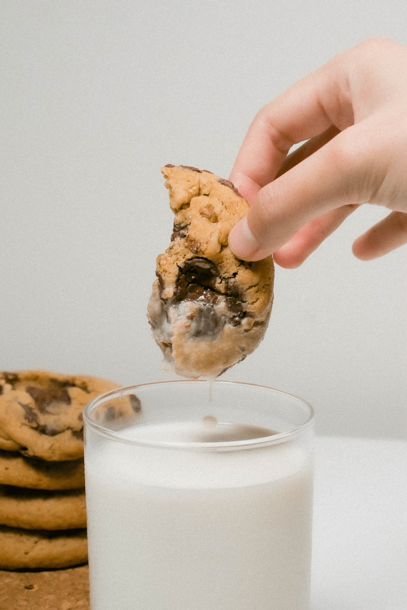 A person enjoys milk and cookies.