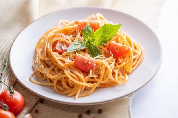 A plate of spaghetti with tomatoes eaten during a small group tour in New York City