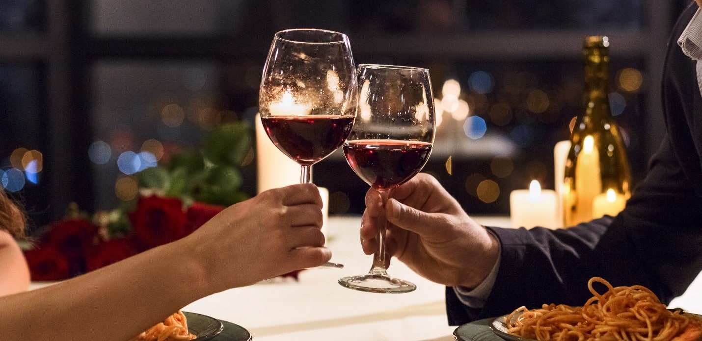 Two people clinking wine glasses during a city trip to New York