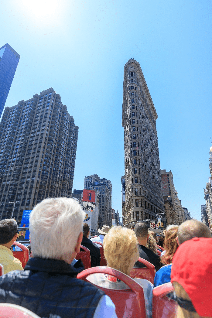 A crowd of people looking at a building during New York City travel guide