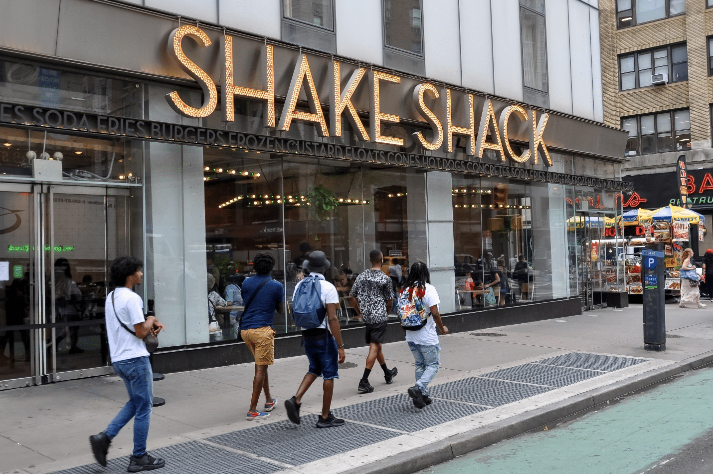 People walking by a Shake Shack during a New York City travel guide