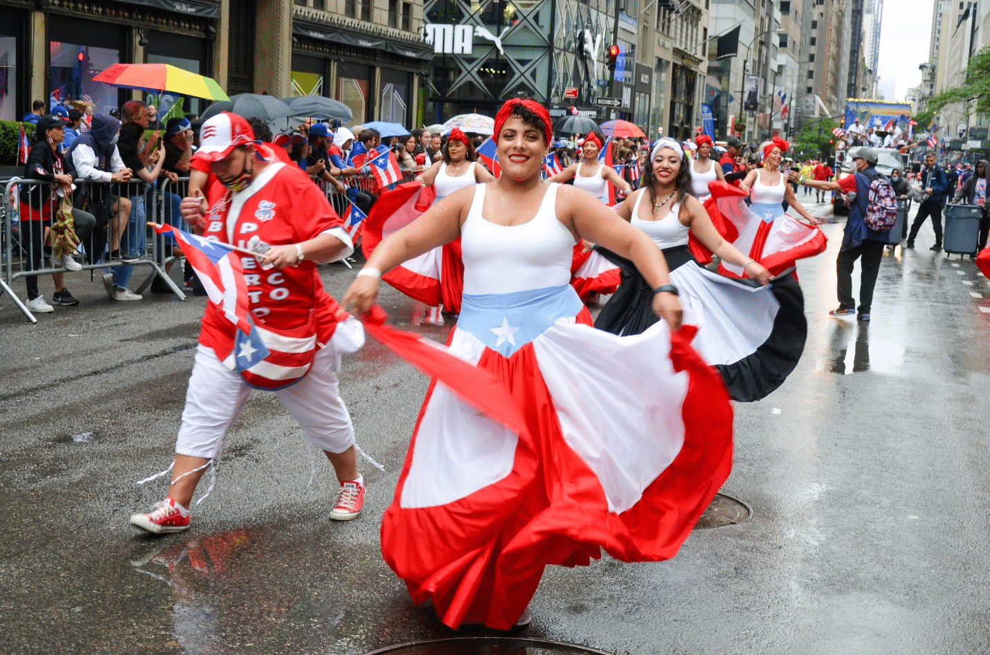 Women dancing in Puerto Rican themed clothing on a street