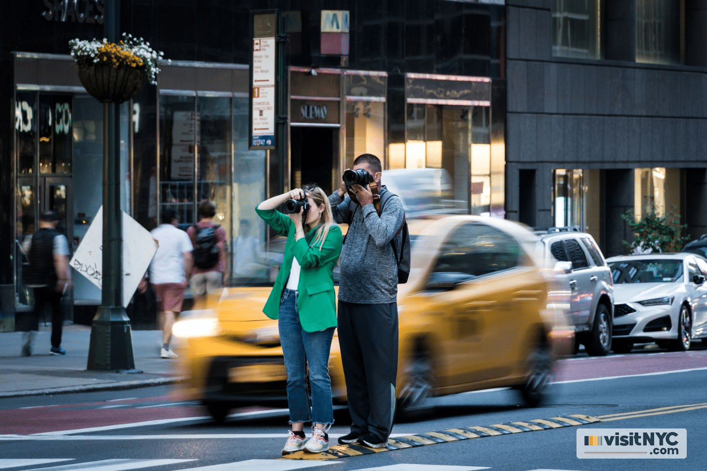 Two people taking photos in a street