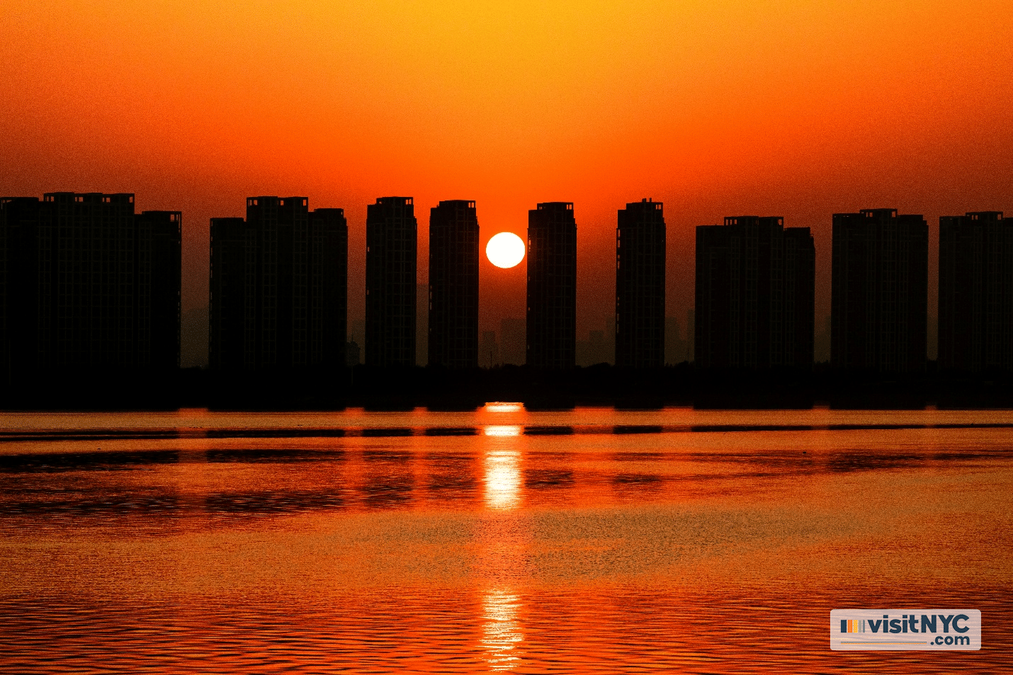 The sun in the center of two buildings from afar