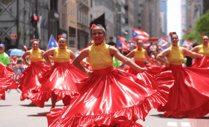 Women dancing in red skirts and yellow tops