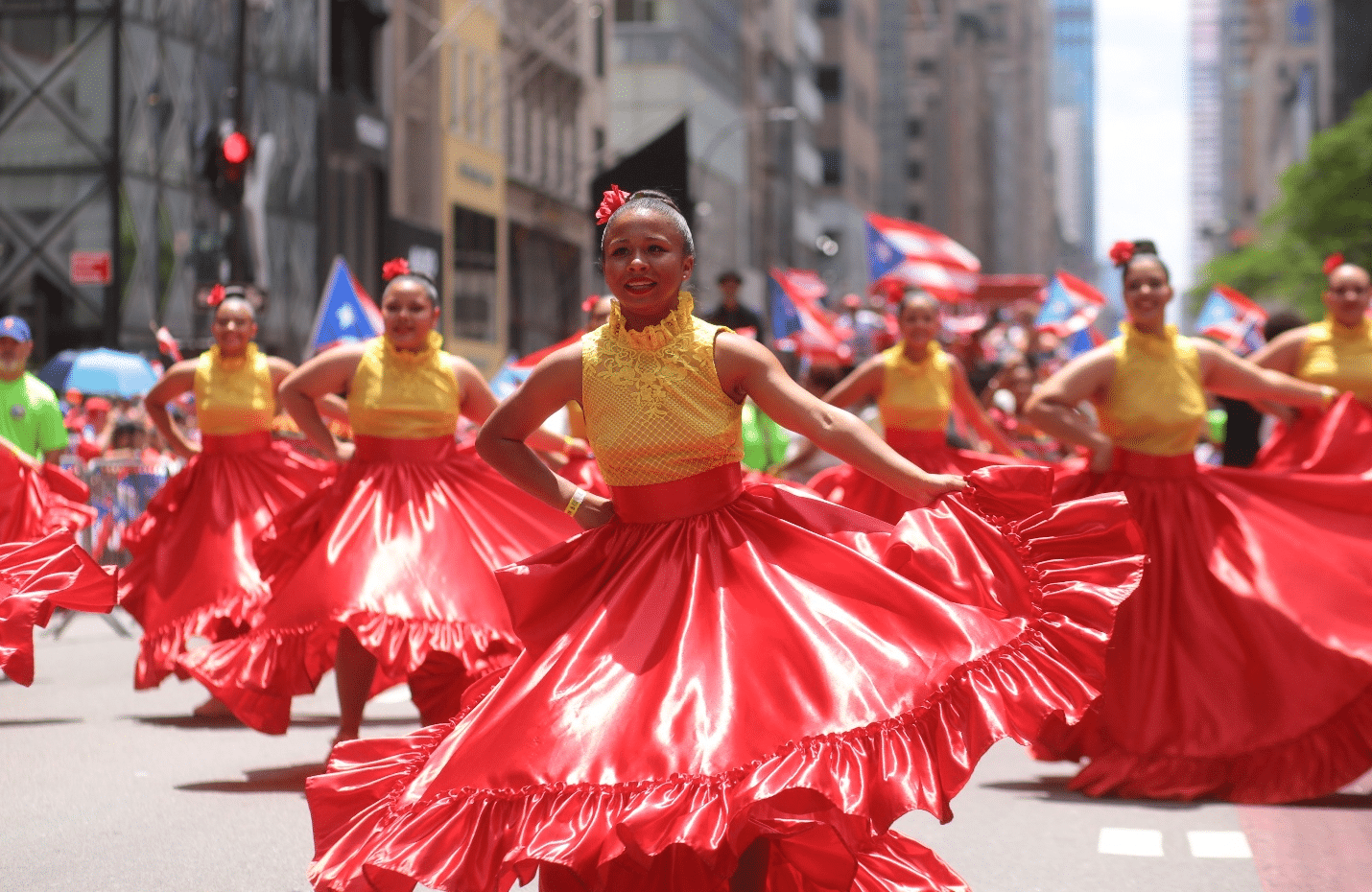 Women dancing in red skirts and yellow tops