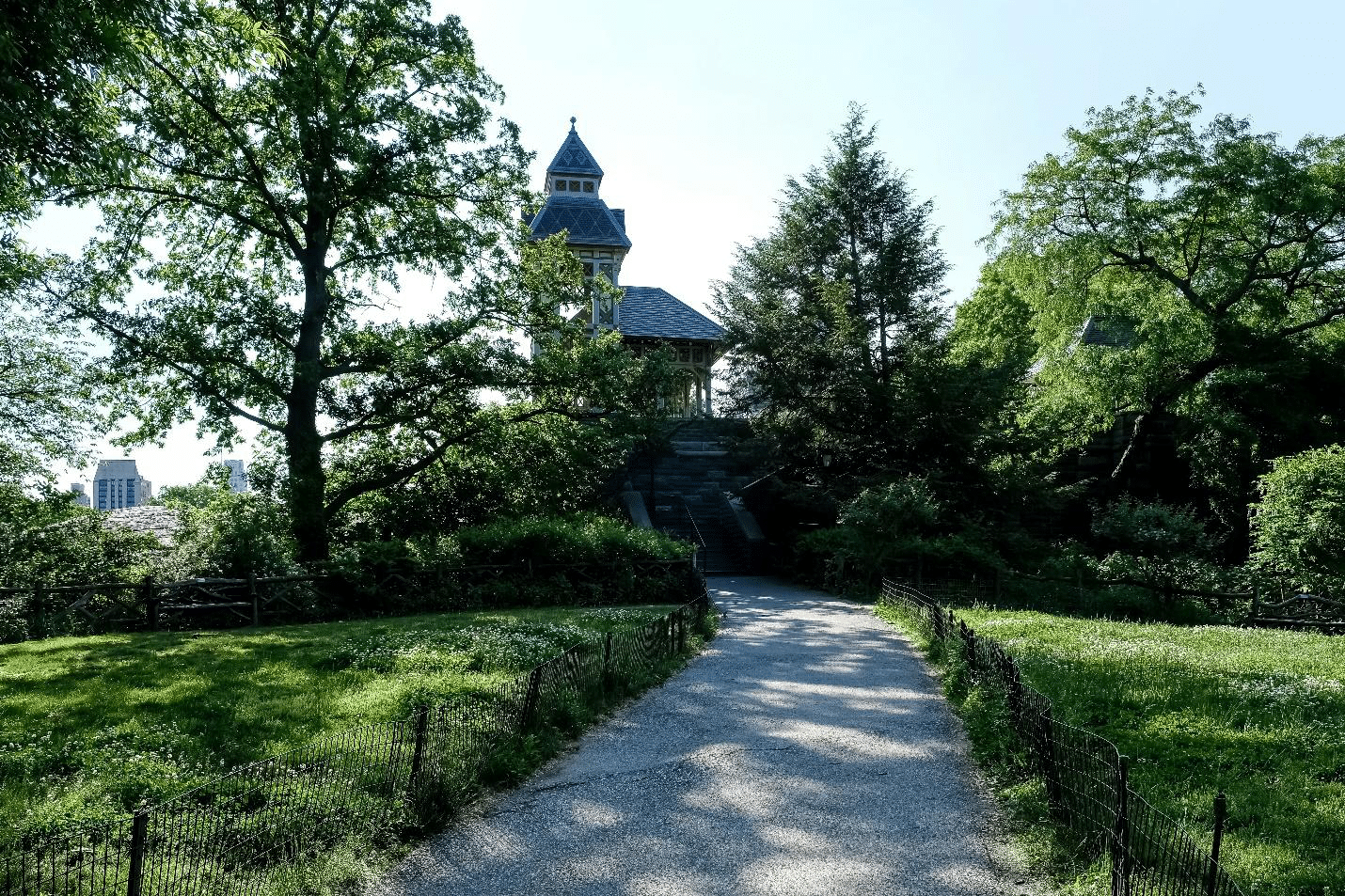 Belvedere Castle peeking through trees from a park pathway.