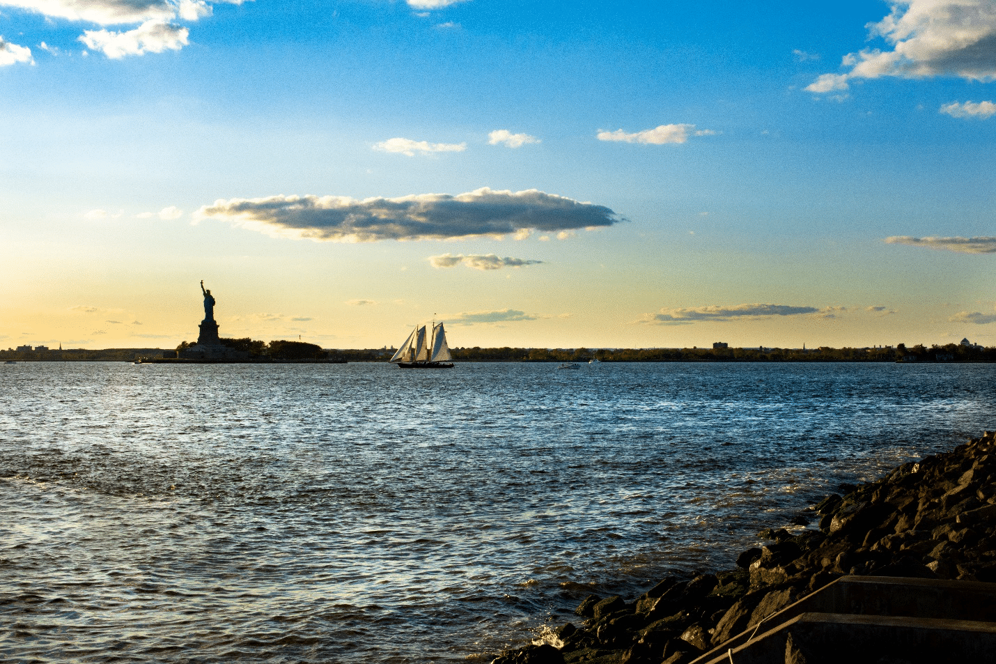The Statue of Liberty seen from afar next to a boat