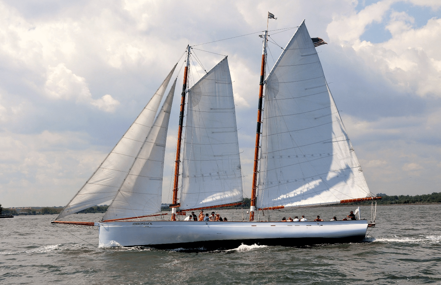 A boat with white sails in the water