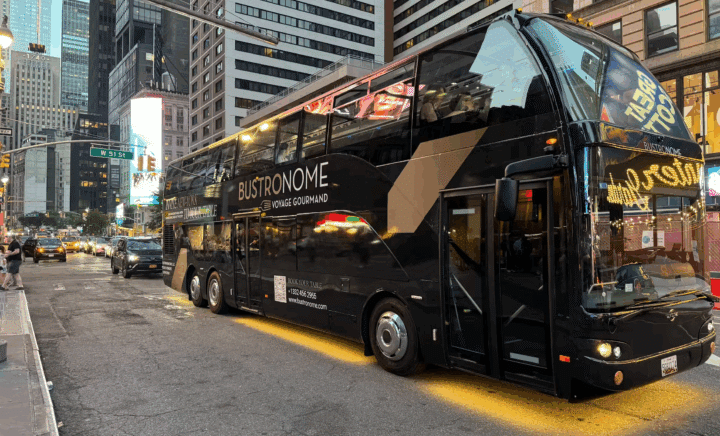 Bustronome NYC glass-roofed bus with guests dining inside while passing New York City landmarks.