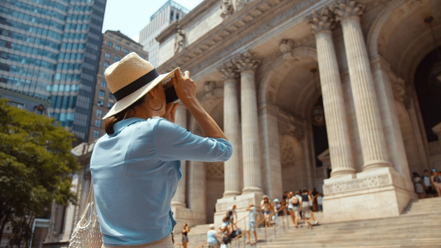 a woman in a hat taking photographs.