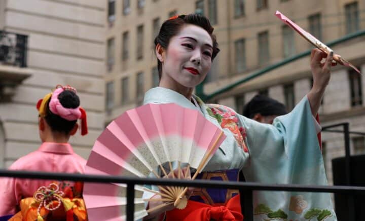 A woman in a kimono holding fans