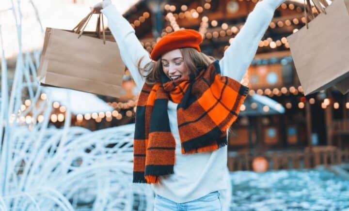 Shoppers enjoy the festive atmosphere at Union Square Holiday Market surrounded by colorful lights and seasonal stalls.