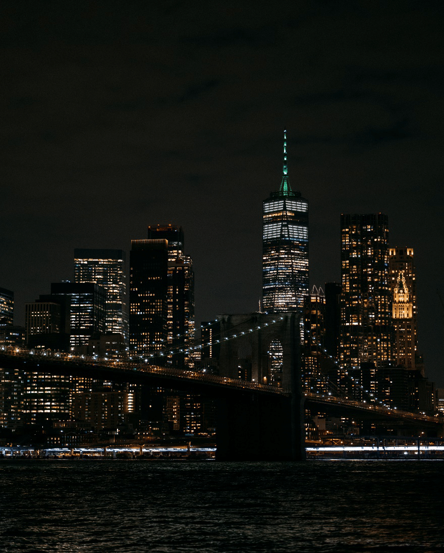 Night view of the New York City skyline with illuminated skyscrapers.
