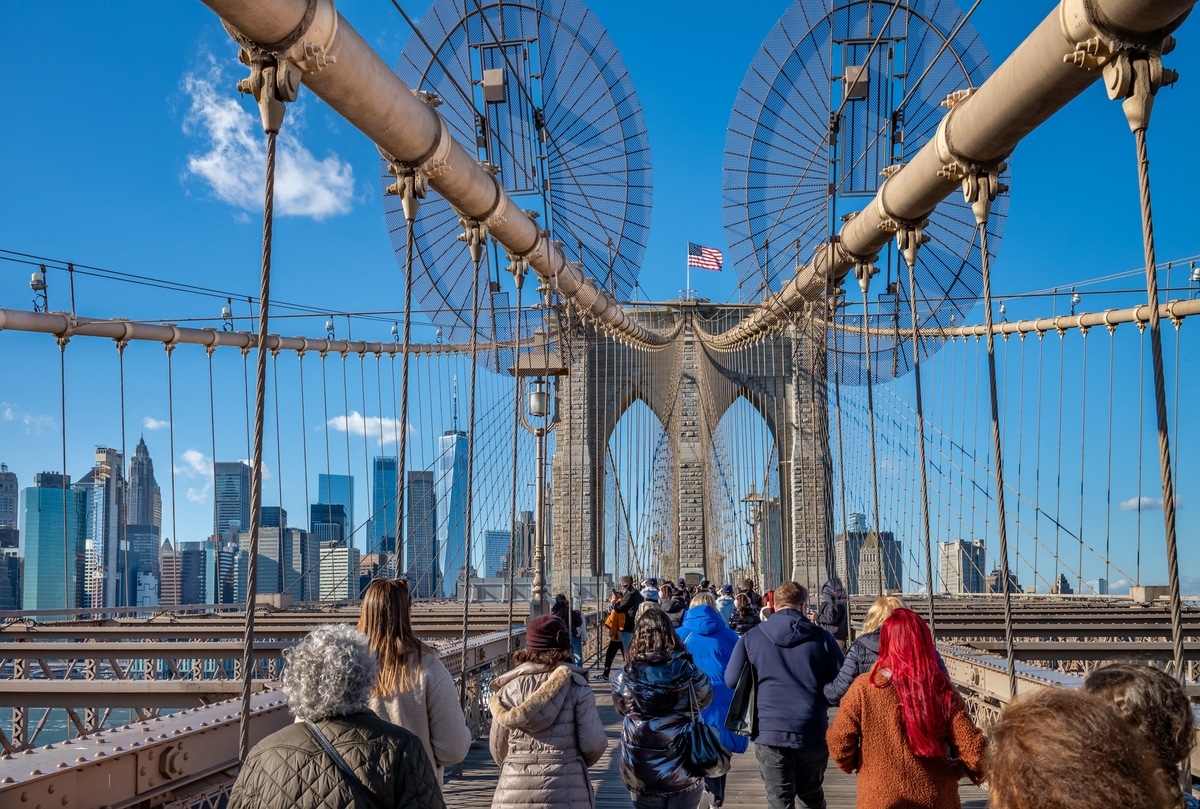 Brooklyn Bridge with Manhattan skyline in the background during autumn sunset in New York City.
