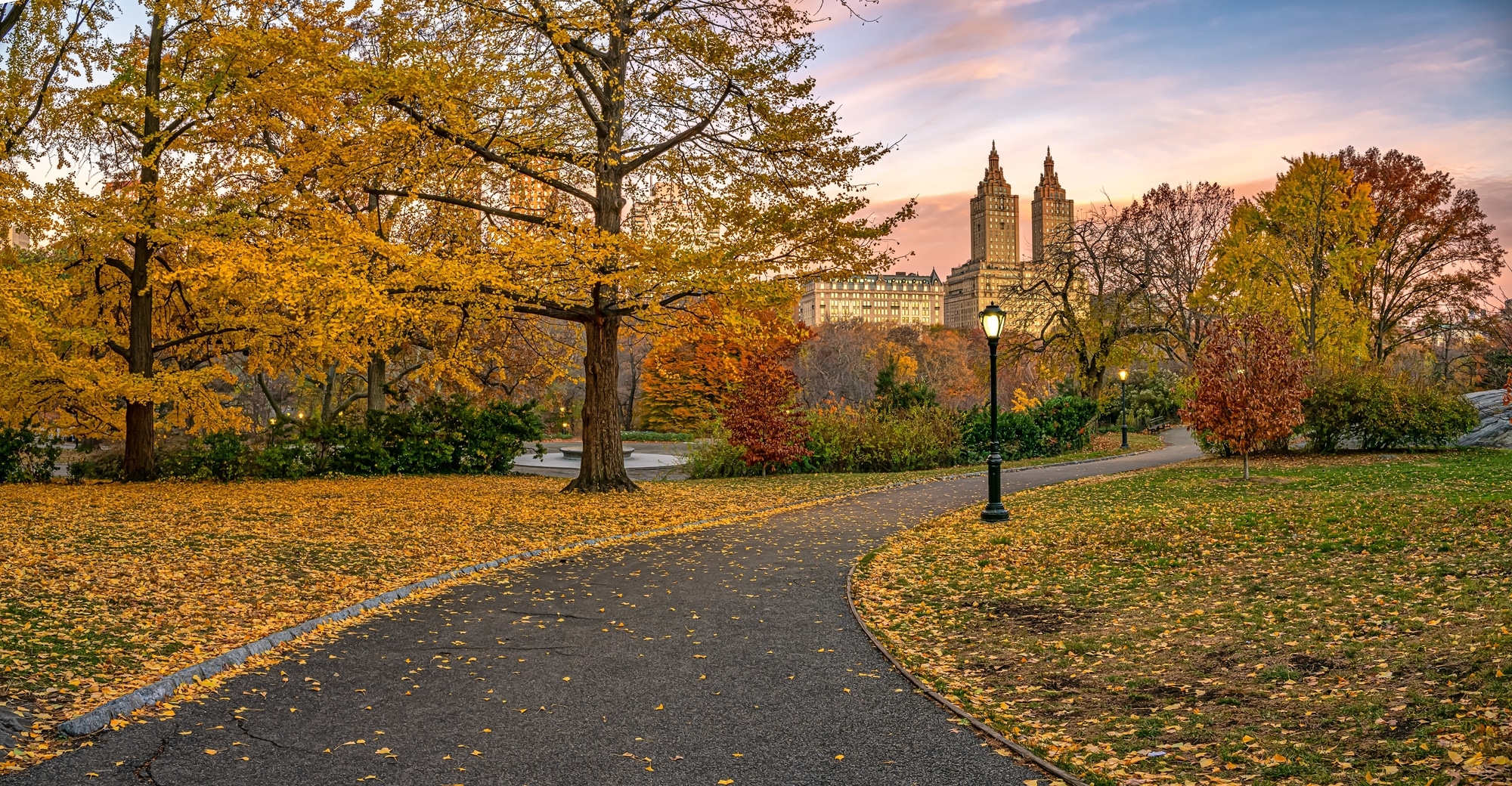 Scenic view of Central Park in New York City during late autumn with colorful trees reflecting on the lake.